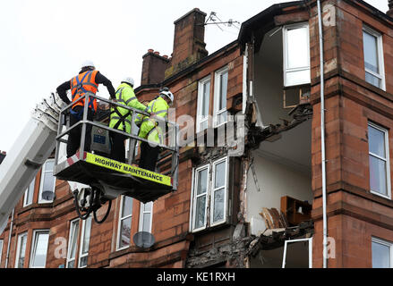 Des ouvriers ont relevé les dommages causés à un bloc d'appartements à Crosshill, dans le côté sud de Glasgow, après qu'une partie du front ait été ramenée par de forts vents alors que Storm Ophelia balaie l'Écosse. Banque D'Images