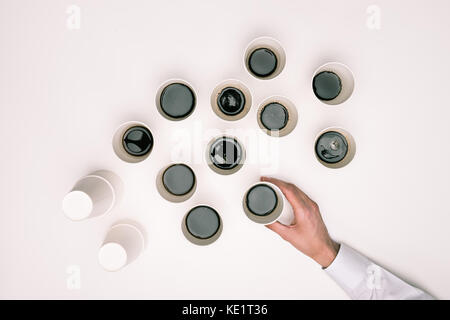 Vue de dessus de la personne de prendre une des nombreuses tasses à café jetables isolated on white Banque D'Images