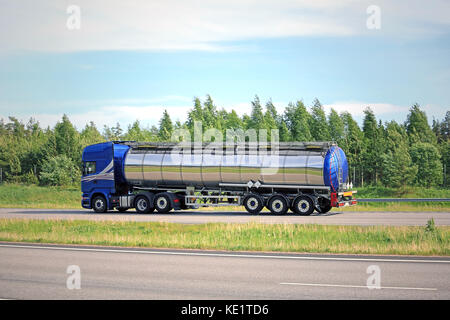 Vue latérale d'un camion-citerne semi bleu sur l'autoroute à l'été, ciel bleu et nuages, copie de l'espace pour votre texte. Banque D'Images