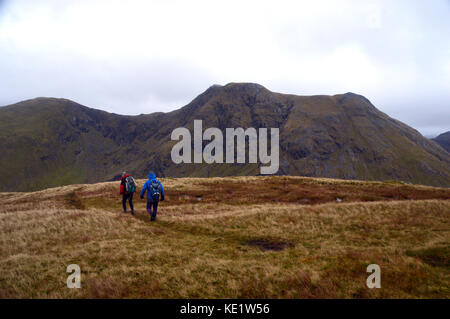 Deux marcheurs de colline sur l'arête est du lighiche avec la corbett meall munro dans sgor na h-ulaidh en arrière-plan dans les highlands écossais. Banque D'Images