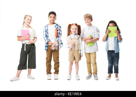 Adorable enfants multiethnique holding manuels et smiling at camera isolated on white Banque D'Images