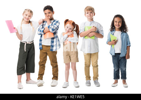 Adorable enfants multiethnique holding manuels et smiling at camera isolated on white Banque D'Images