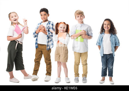 Adorable enfants multiethnique holding manuels et smiling at camera isolated on white Banque D'Images