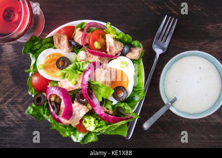 Photo prise à la verticale de la salade de thon avec vin rose, fourche, sauce Banque D'Images