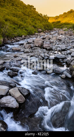 Vue typique dans le parc national de Skaftafell à la rivière et des pierres, de l'eau dans le motion blur, l'Islande en été, coucher de soleil couleurs Banque D'Images