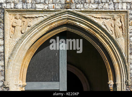 Une vue des spandrels au-dessus de la porte d'entrée dans le porche sud de l'église de Saint-Pierre à Ringland, Norfolk, Angleterre, Royaume-Uni. Banque D'Images