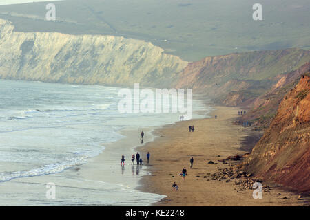 Les gens qui marchent sur la plage à Compton Bay sur l'île de Wight sur une vague et brumeux jour d'automne. Banque D'Images