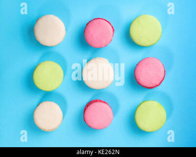 Macarons colorés sur fond bleu. Vue de dessus Banque D'Images