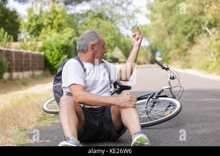 Homme est tombé sur son vélo Banque D'Images