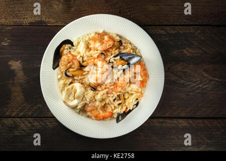 Risotto aux fruits de mer sombre sur fond rustique avec copyspace Banque D'Images