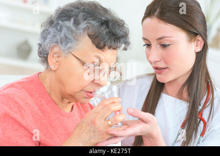 Helping old lady de prendre ses médicaments Banque D'Images