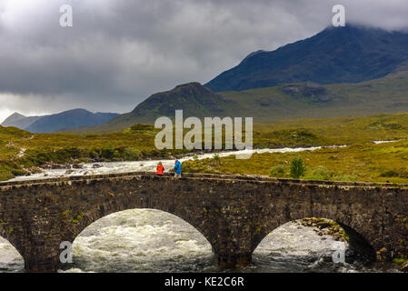 Île de Skye, ÉCOSSE - 11 août 2017 - Vue du pont de sligachan cuillin hills avec sur l'île de Skye avec deux touristes qui recherchent le panorama. Banque D'Images