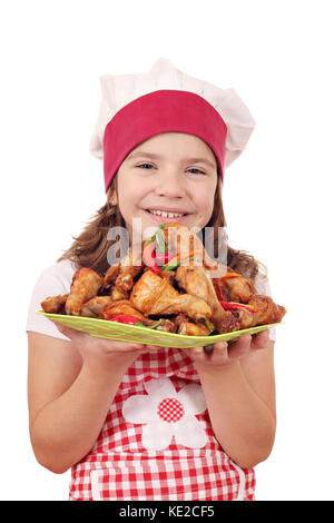 Happy little girl cuisiner avec des pilons de poulet sur la plaque Banque D'Images