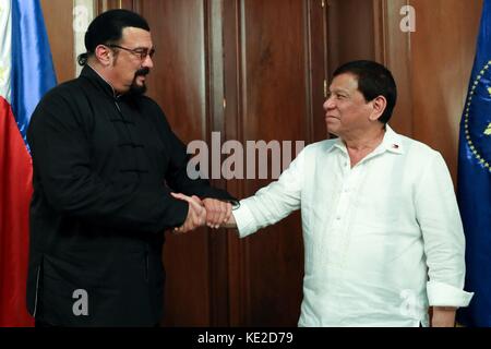 Le président philippin Rodrigo Duterte, à droite, serre la main de la star d'action Steven Seagal au Palais Malacanang le 12 octobre 2017 à Manille, Philippines. Seagal est aux Philippines pour trouver un nouveau film. Banque D'Images