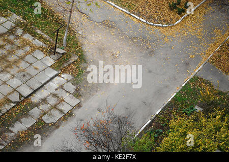 Vue de dessus d'une ancienne route de cour couverte par la chute d'automne les feuilles d'automne. l'humeur. Banque D'Images