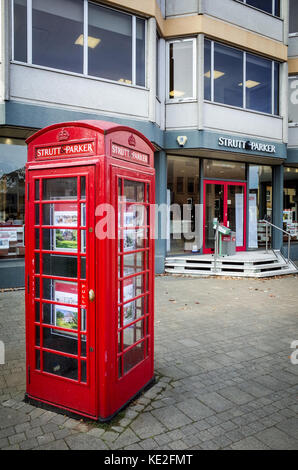 Strutt et Parker Estate Agents in Cambridge, avec une cabine téléphonique adapté afficher les annonces devant les bureaux Banque D'Images