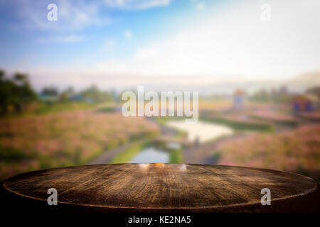 Table en bois vides de mise au point sélectionnée et l'avis de nombre d'arrière-plan flou fleur avec bokeh image. Pour votre photomontage ou l'affichage des produits. Banque D'Images