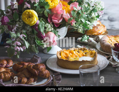 Table de fête avec de gros bouquet, des gâteaux faits maison et des scones Banque D'Images