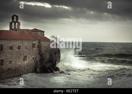 Avec de grandes vagues de tempête orageuse au littoral s'écraser sur les murs d'un château médiéval sur mer terre et ciel dramatique sombre dans la saison d'automne sur le coût de la mer Banque D'Images