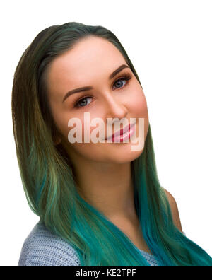 Jeune femme aux cheveux bleu et vert pose sur un fond blanc, souriant, regardant la caméra d'un point de vue du côté incliné. Banque D'Images