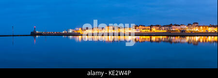 Vue panoramique du front de mer de Margate reflétée dans le bassin de baignade au crépuscule. Banque D'Images