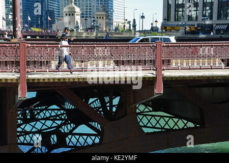 Deux personnes traversent la rivière Chicago sur le wabash avenue bridge dans le centre-ville de Chicago Loop. Banque D'Images