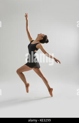 Vue latérale du jeune ballerine en noir danseur posant élégamment Banque D'Images