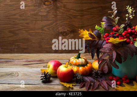 Arrangement de Thanksgiving avec rowan berries et feuilles en vase turquoise, citrouilles, pommes, cônes, copy space Banque D'Images