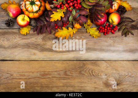 Automne fond rustique avec les cônes, les pommes, citrouilles, red rowan et jaune feuilles de chêne, copy space Banque D'Images