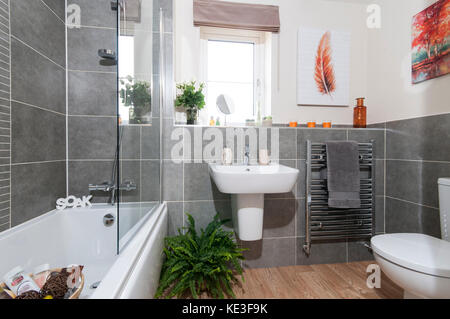 Salle de bains familiale avec des carreaux gris et d''un sèche-serviettes Banque D'Images