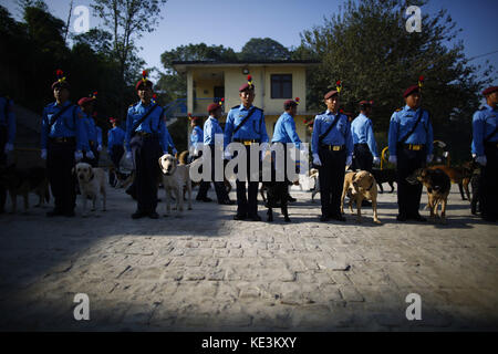 Katmandou, Népal. 18 octobre 2017. Le personnel de la police népalaise se tient à côté de leurs chiens dressés lors d'un spectacle dans le cadre des célébrations et de l'honneur pendant le festival canin ou Kukkur Tihar qui a lieu le deuxième jour du deuxième plus grand festival religieux de cinq jours de Tihar ou Diwali connu sous le nom de festival des lumières à l'école centrale de formation canine de la police à Katmandou, Népal, le mercredi 18 octobre 2017. Chaque jour pendant le festival de cinq jours, les dévots adorent les corbeaux, les chiens et les vaches, qui sont considérés comme une figure maternelle signifiant la relation entre les humains, la Déité et les animaux. (Crédit Ima Banque D'Images