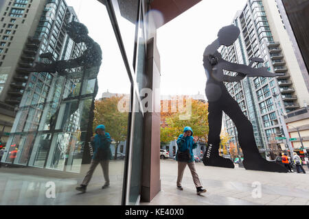 Seattle, États-Unis. 18 oct, 2017. SEATTLE, Washington : femme marche par le martelage l'homme au Seattle Art Museum, la première tempête de la saison de fouet la ville avec des vents forts et de la pluie. le National Weather Service a un haut de vent fort en vigueur et une forte pluie Comité consultatif par le week-end pour la plus grande partie de l'ouest de Washington. crédit : Paul christian gordon/Alamy live news Banque D'Images