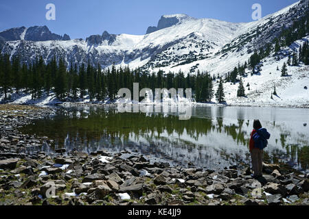 Randonneur au lac Stella avec le mont Wheeler dans la neige fraîche, parc national du Grand bassin, Nevada, États-Unis Banque D'Images