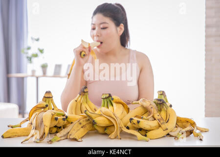 Portrait de jeune femme enrobée de manger les bananes Banque D'Images