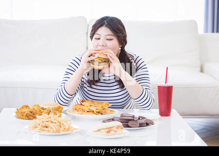 Portrait de jeune femme enrobée de manger fast-food Banque D'Images