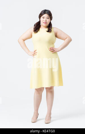 Young smiling grosse femme en jaune dress posing Banque D'Images