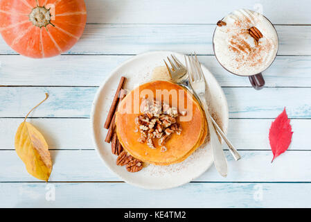 Crêpes à la citrouille avec noix de pécan, miel et une tasse de café. la composition des aliments de l'automne sur tableau blanc. Vue de dessus, la composition des plats Banque D'Images