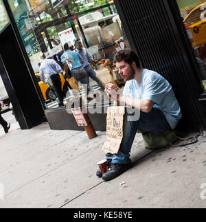 La ville de New York, USA - 08 juillet 2015 : Sans-abri manin le centre-ville de Manhattan pour les appels de l'argent pour un billet. Selon une estimation récente dans la ville il ya un Banque D'Images