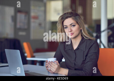 Jeune et belle businesswoman fatigué de travailler au bureau.woman holding her head. Banque D'Images