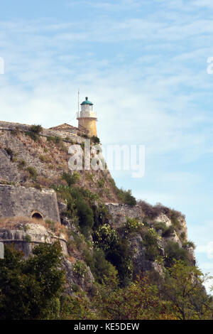 Le phare sur un rocher à l'entrée de corcyre, Corfou, Grèce avec des clous à haute altitude contre ablue ciel d'été. Banque D'Images