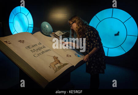 Un visiteur regarde un livre de « soin des créatures magiques » lors d'un aperçu de presse pour l'exposition Harry Potter : une histoire de la magie à la British Library de Londres. Banque D'Images