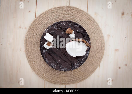 Un beau gâteau bounty végétalien premières décorées dans une forme exotique sur une table en bois. Banque D'Images