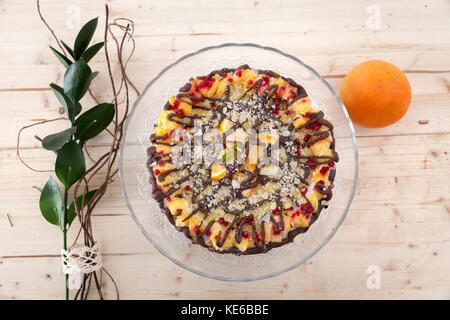 Un beau gâteau végétalien premières décorées sur un ensemble de support de verre avec une orange et une fleur. Banque D'Images