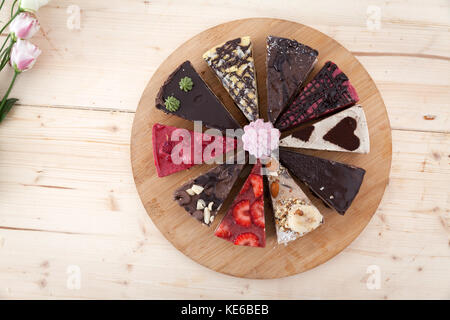 Une plaque de bois avec différents types de gâteau végétalien premières dans un peu de pâtisserie. Banque D'Images