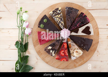 Différents types de gâteaux végétalien premières sur une plaque de bois dans une petite pâtisserie. Banque D'Images