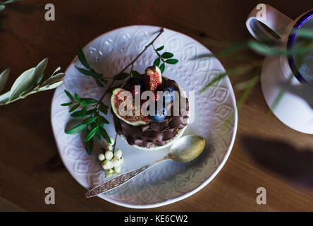 Cupcake chocolat aux figues et petits fruits sur table en bois. Vue de dessus Banque D'Images