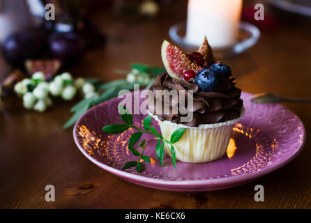 Cupcake chocolat aux figues et fruits rouges sur la table de fête Banque D'Images