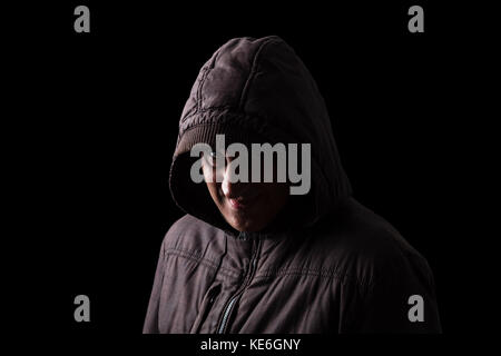 Homme mature avec peur et sourire effrayant de se cacher dans l'ombre, debout dans l'obscurité / smiling méchants malveillants dangereux dépravé vicieux stalker Banque D'Images