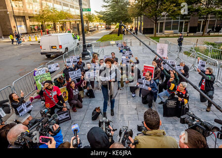 New York, États-Unis. 17 octobre 2017. Musicien K Sloan, chantant l'hymne national tandis que les manifestants se tiennent au genou - en prévision de la rencontre de la Ligue d'automne de la NFL à New York le 17 octobre 2017 ; Des groupes de défense organisent une manifestation qui se tient aux genoux devant l'hôtel Conrad New York, pour exhorter Roger Goodell et les propriétaires d'équipes de la NFL à résister aux pressions de l'administration Trump et à défendre le droit des joueurs de manifester. Crédit : Erik McGregor/Pacific Press/Alay Live News Banque D'Images