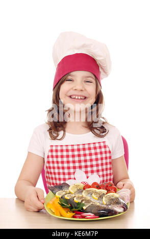 Happy little girl cook avec de la truite Banque D'Images